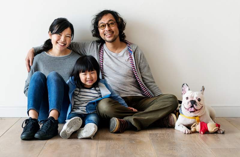 Smiling Asian family with dog - Training resources for dog owners to help them have fun with their dogs